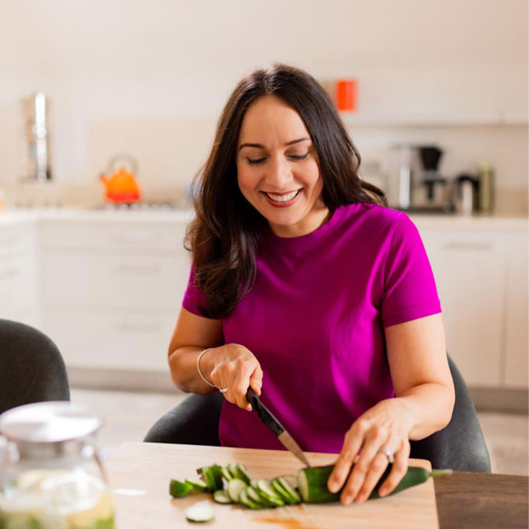 Angeli Degardin Nutrition wearing berry top chopping cucumber